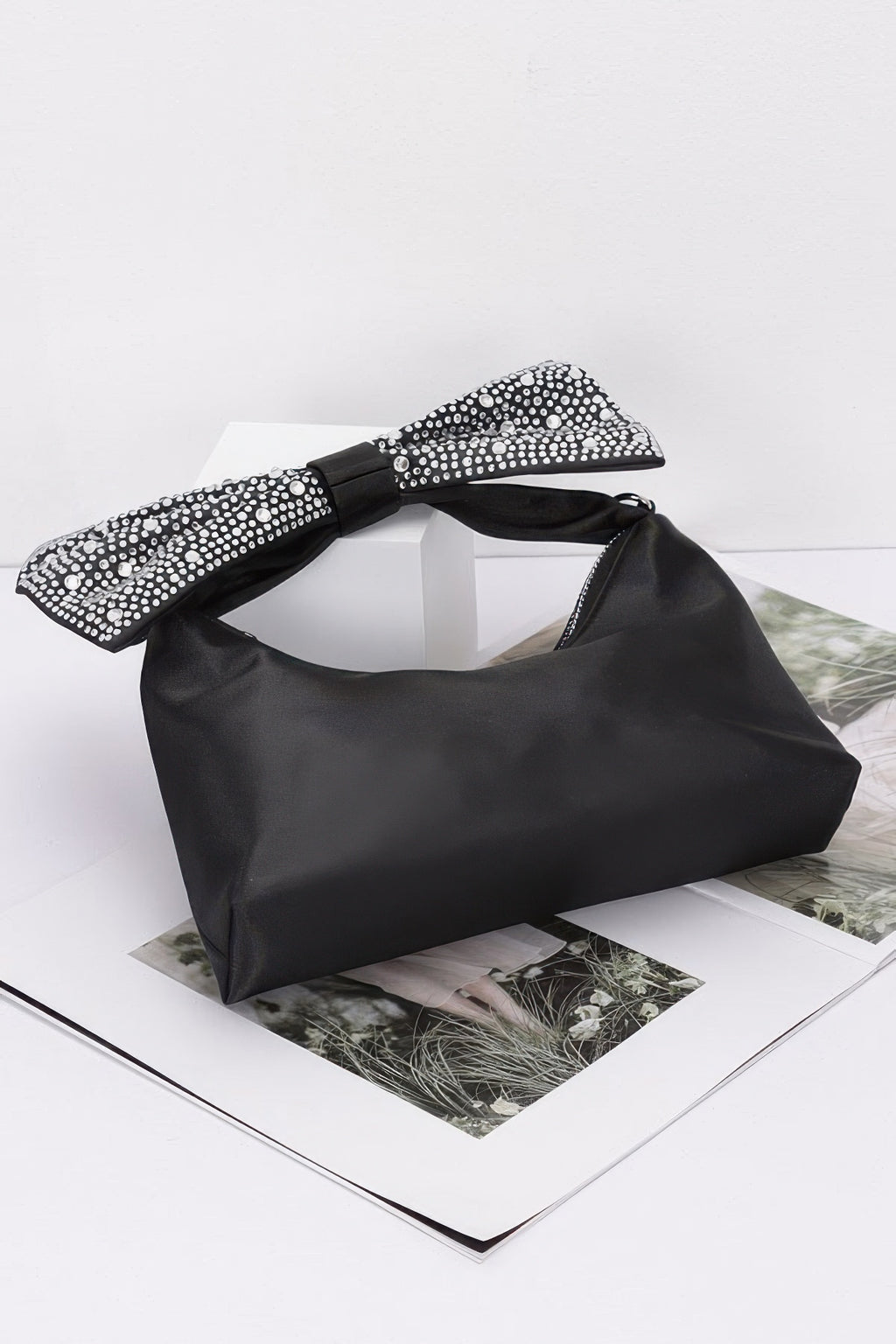 Black nylon clutch with embellished bow top and chain strap