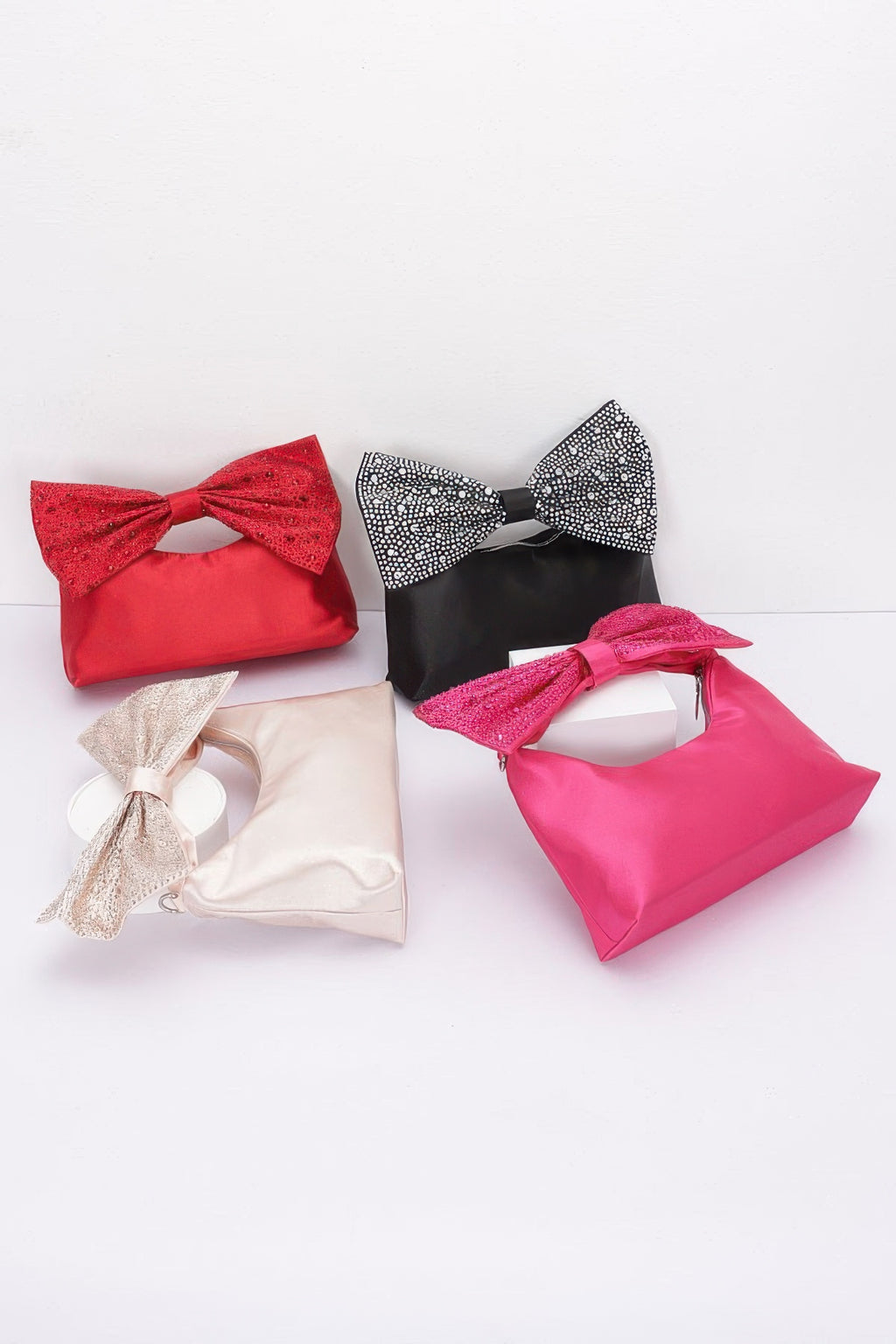 Assorted bow handle clutches: red, black, fuchsia, and cream with rhinestones