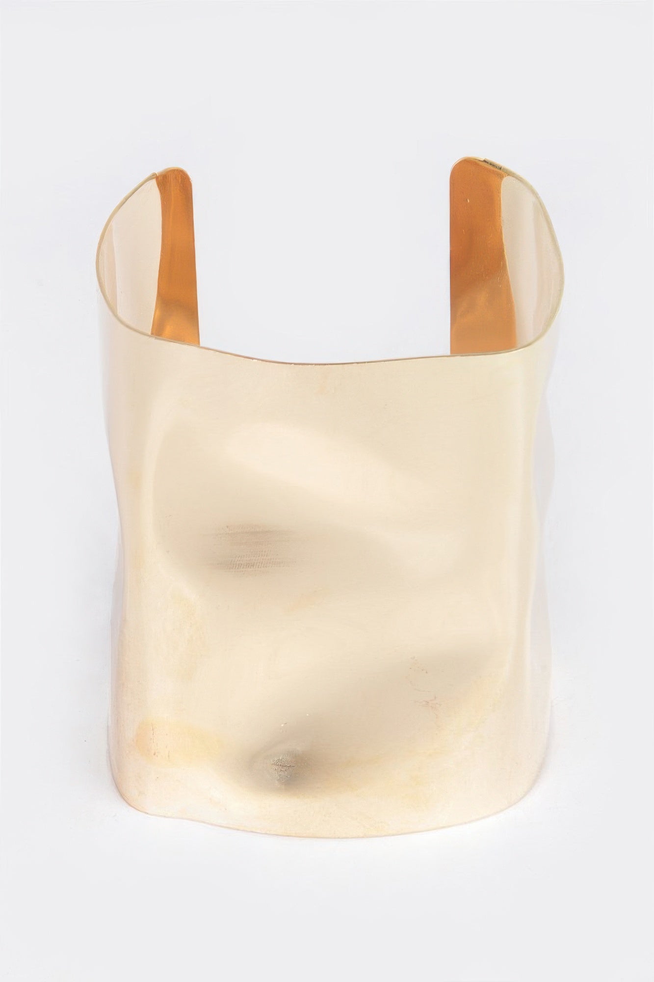 Gold-tone metal cuff bracelet with wide open band and smooth curved edges