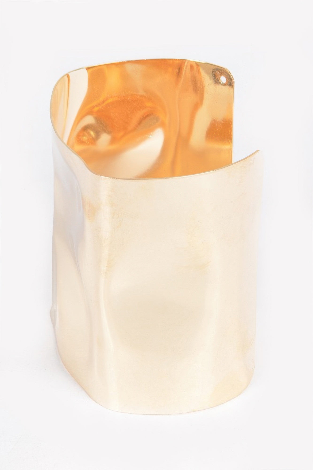 Gold-tone metal cuff bracelet with glossy finish and rounded top edges