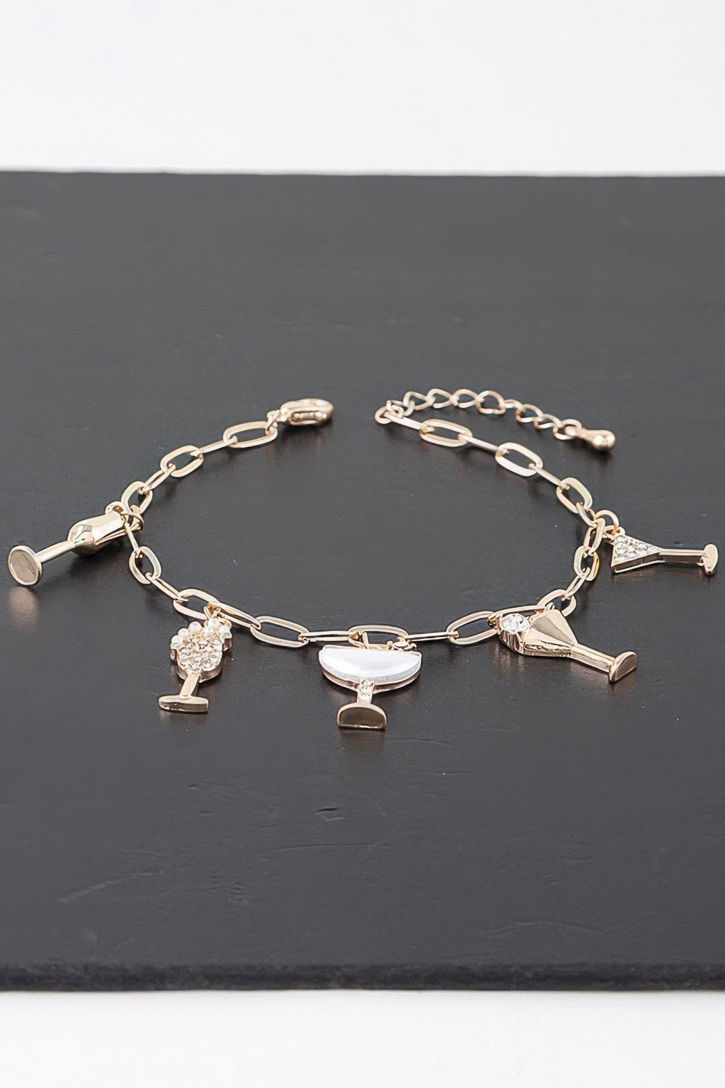 Goldfarbenes Kettenarmband mit mehreren Drink-Charms und funkelnden Gläsern