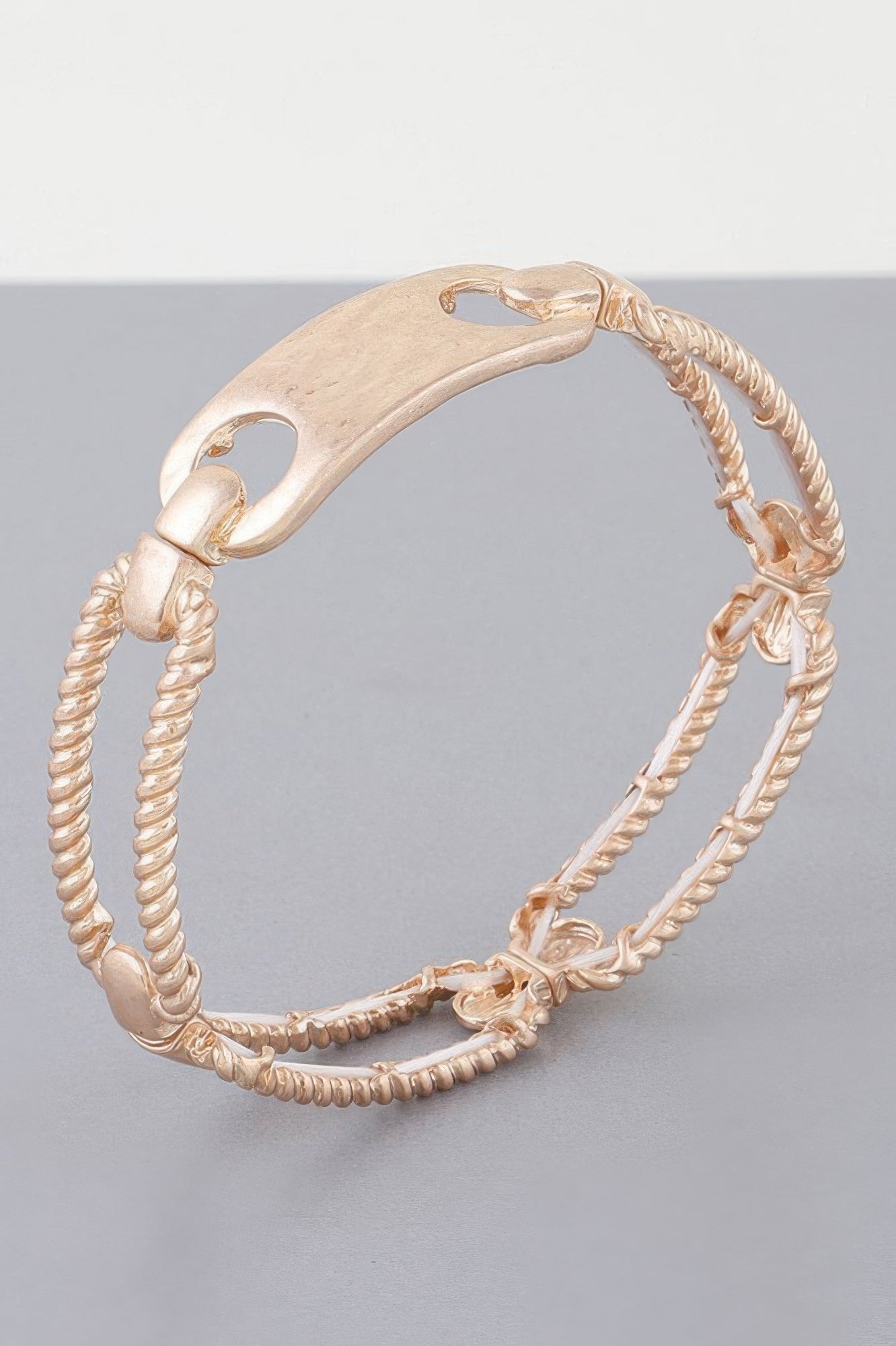Twisted plate cuff bracelet in gold tone with braided rope links and clasp