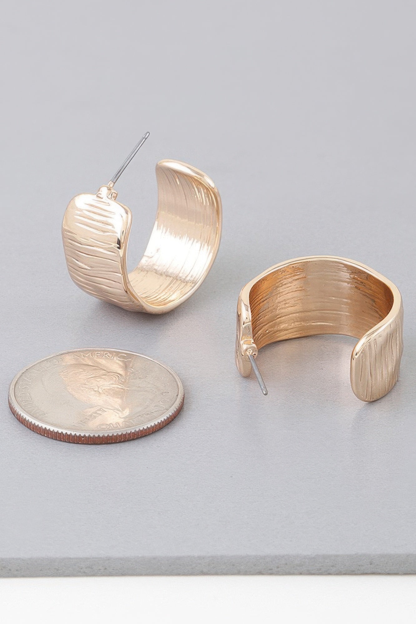 Abstract Cut hoop earrings doradas, aro ancho ovalado con relieve horizontal