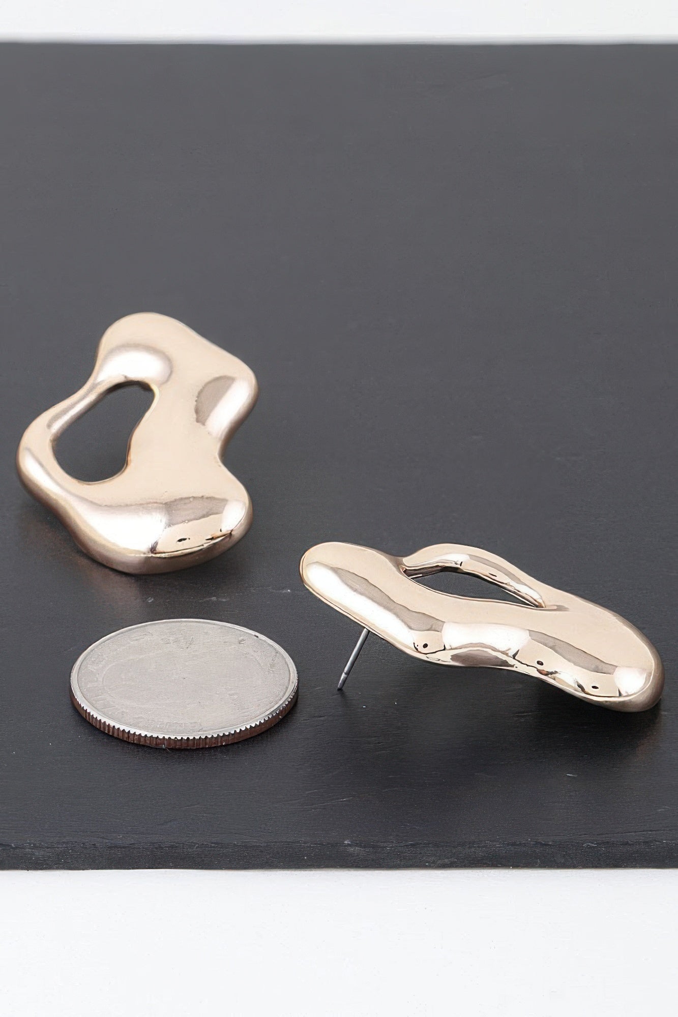 Gold-tone abstract puddle earring pair, reflective sculpted form with straight post