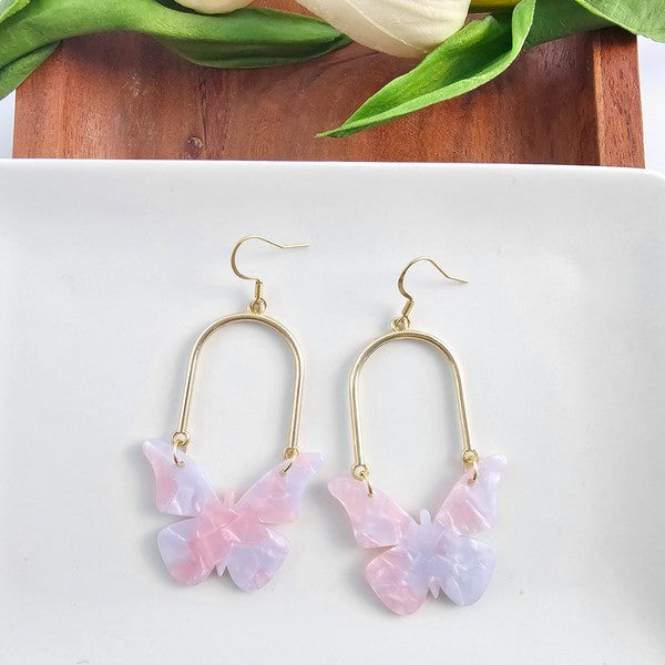 Pink butterfly drop earrings with gold oval hoops and layered butterfly studs