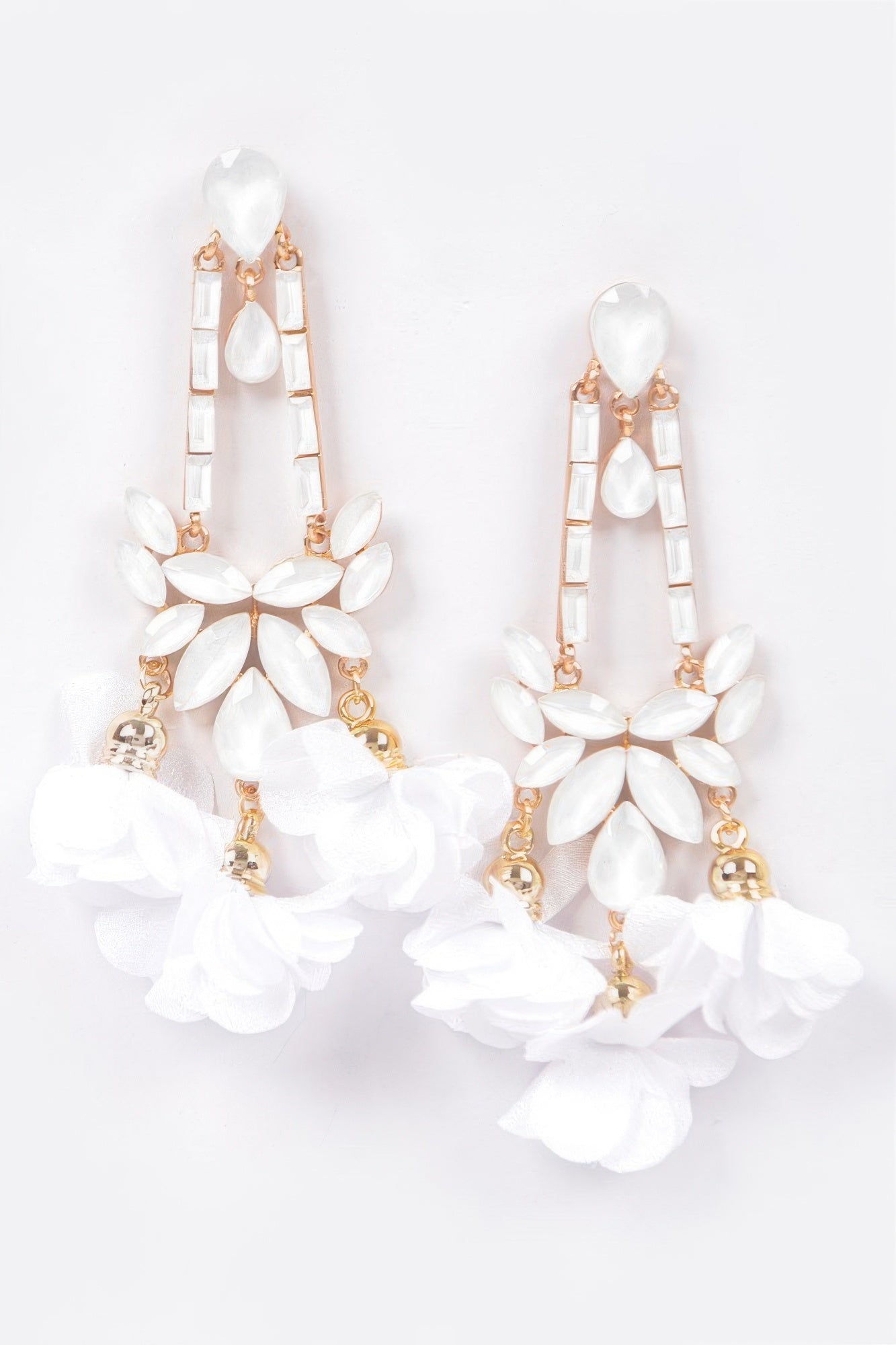 White flower drop earrings with stacked petal charms and gold-tone hardware