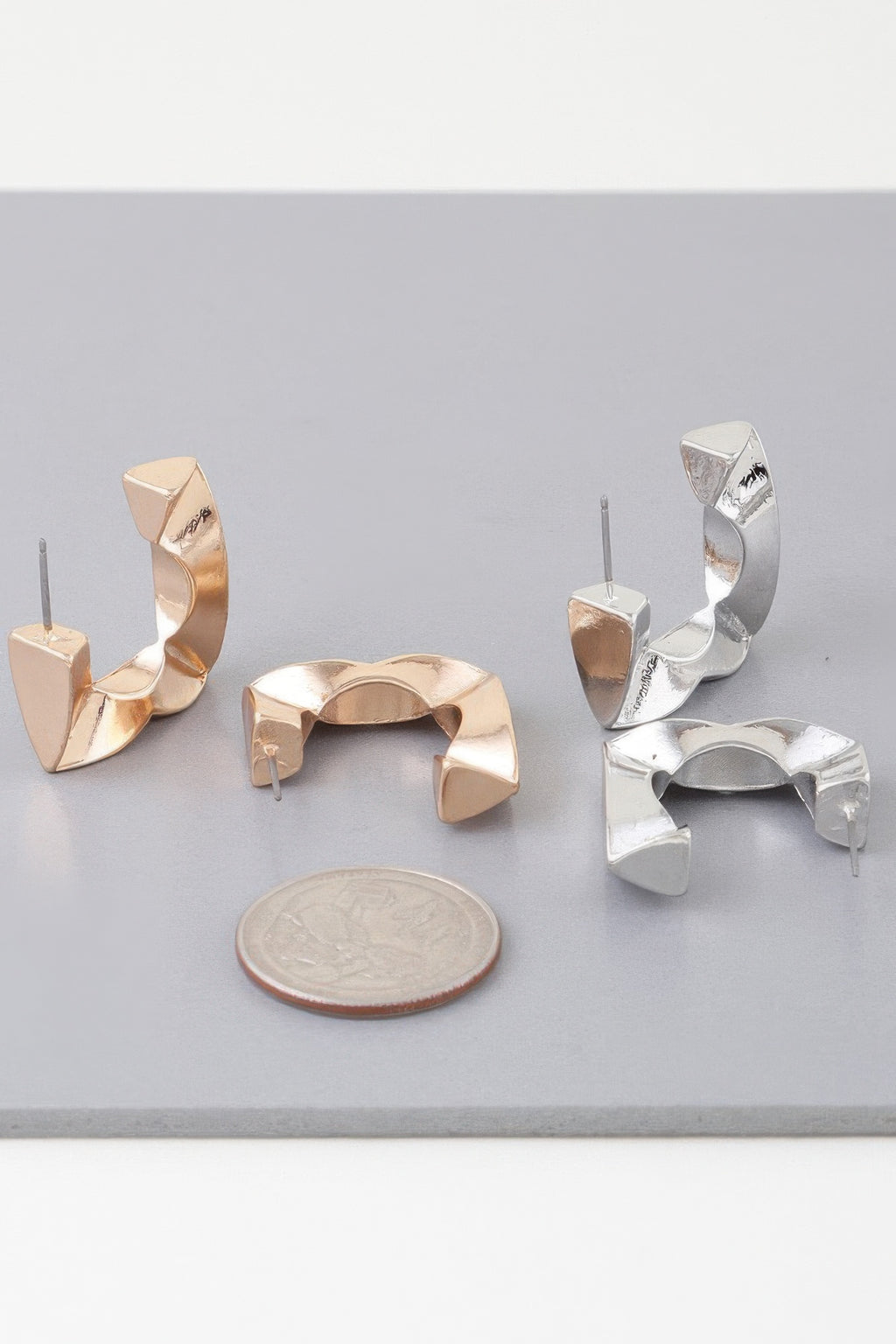 Set of geometric cubic hoop earrings: gold and silver tones, faceted open arches.