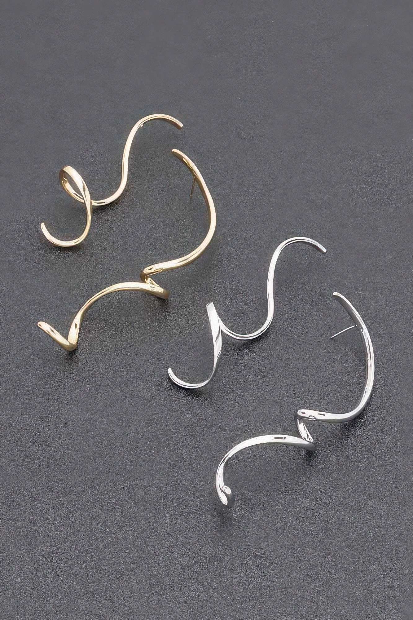 Set of gold and silver twist dangle earrings, curved open-hoop style