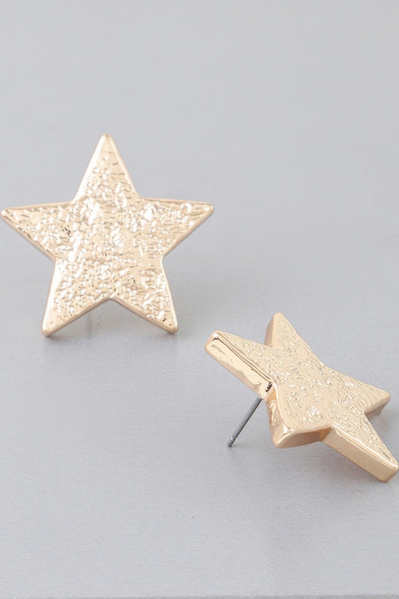 Gold hammered star earrings with metal post backs visible