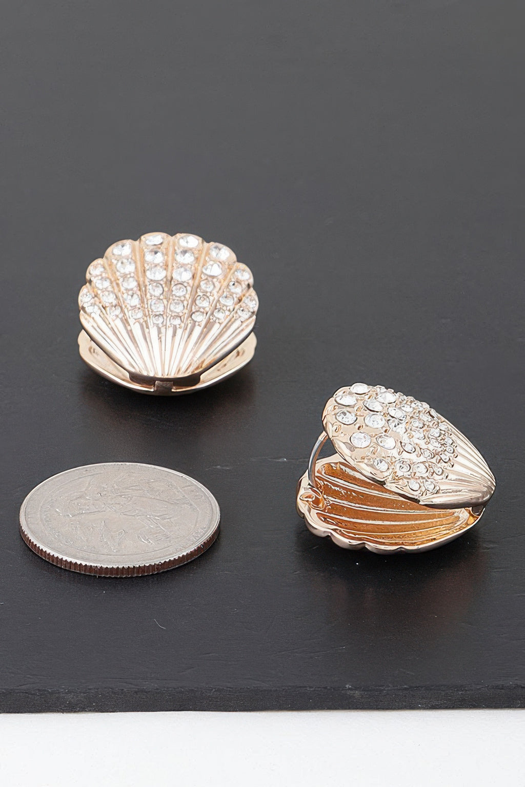 Gold-tone clam shell earring stud with clear rhinestones, angled view