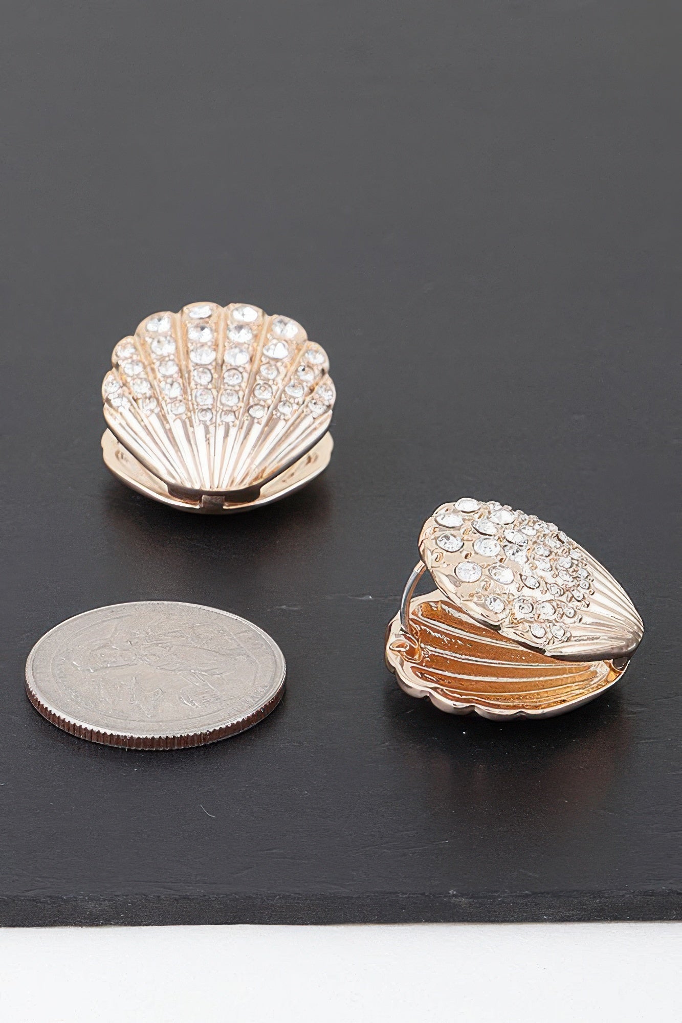 Gold-tone clam shell earring stud with clear rhinestones, angled view