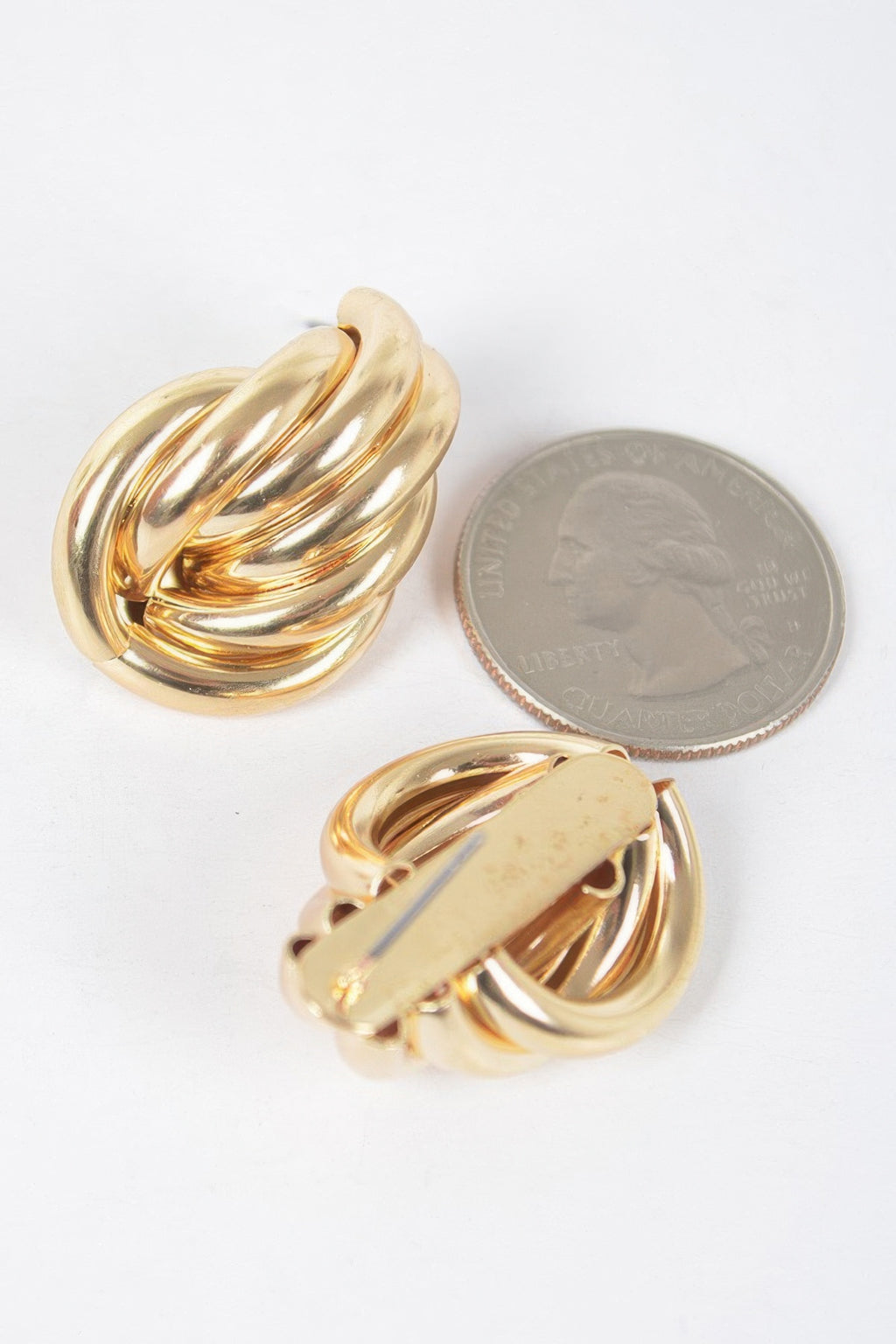 Gold metal stud earrings close-up, scalloped teardrop shell studs with shine