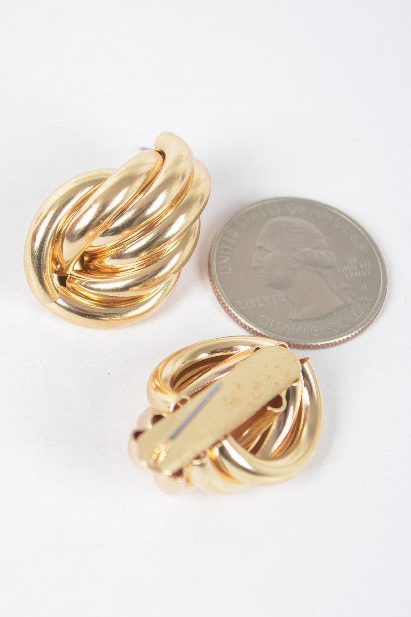 Gold metal stud earrings close-up, scalloped teardrop shell studs with shine