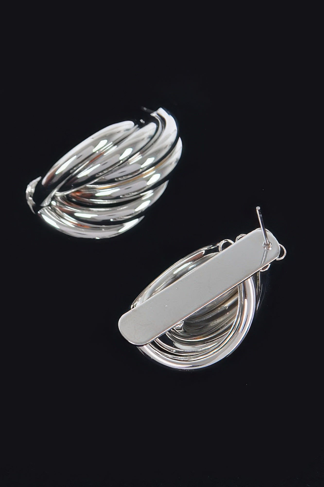 Silver metal stud earrings, teardrop scalloped swirl design with visible posts