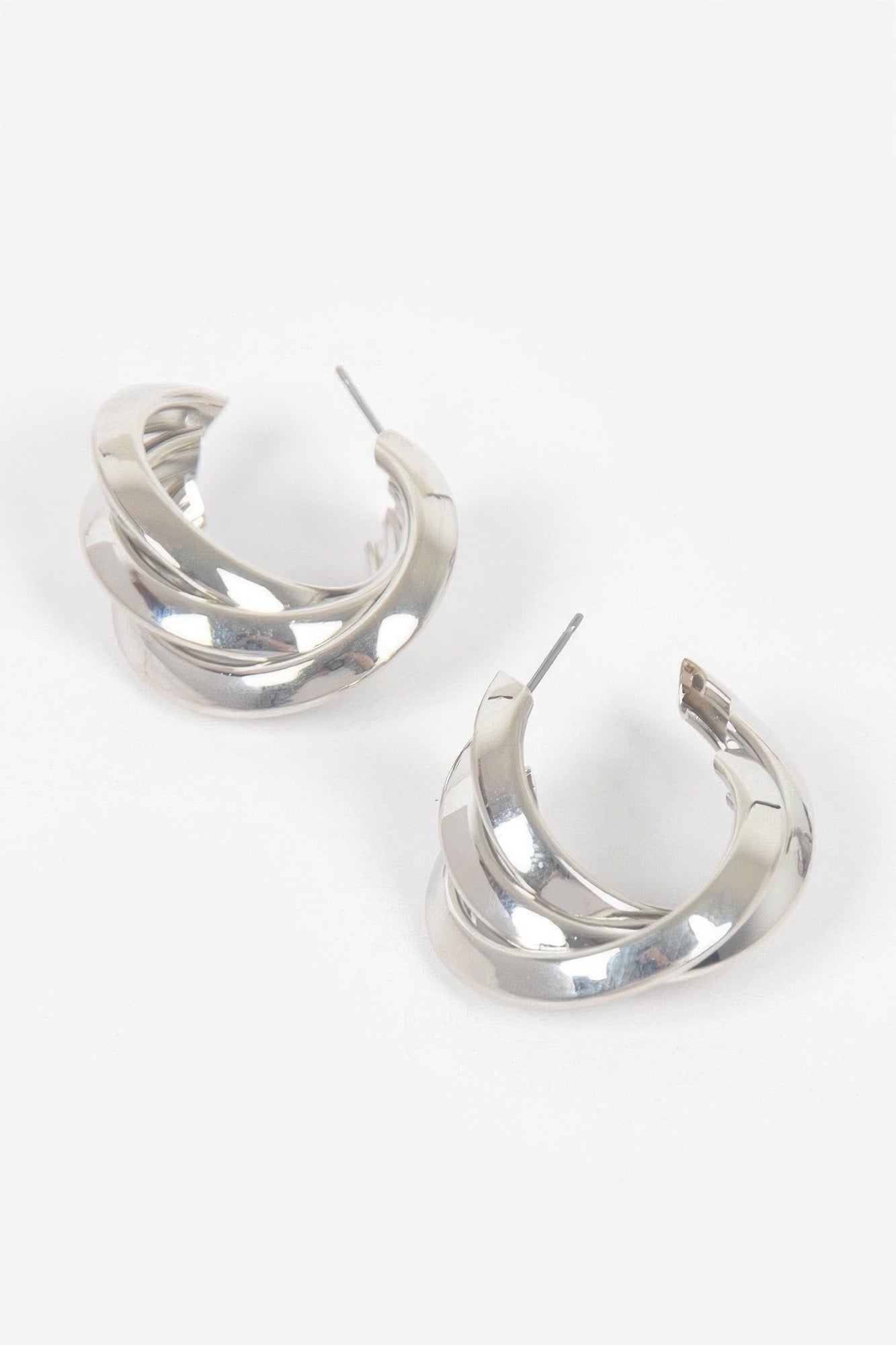 Small silver hoop earrings with layered metal bands and stud backing