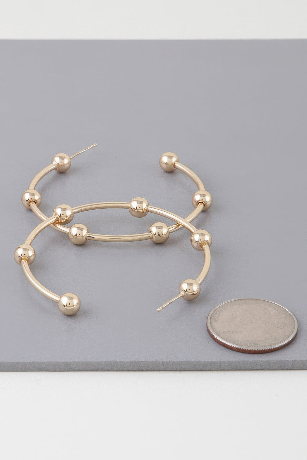 Goldfarbene Hoop-Ohrringe mit mehreren glänzenden Kugelperlen am Kreis
