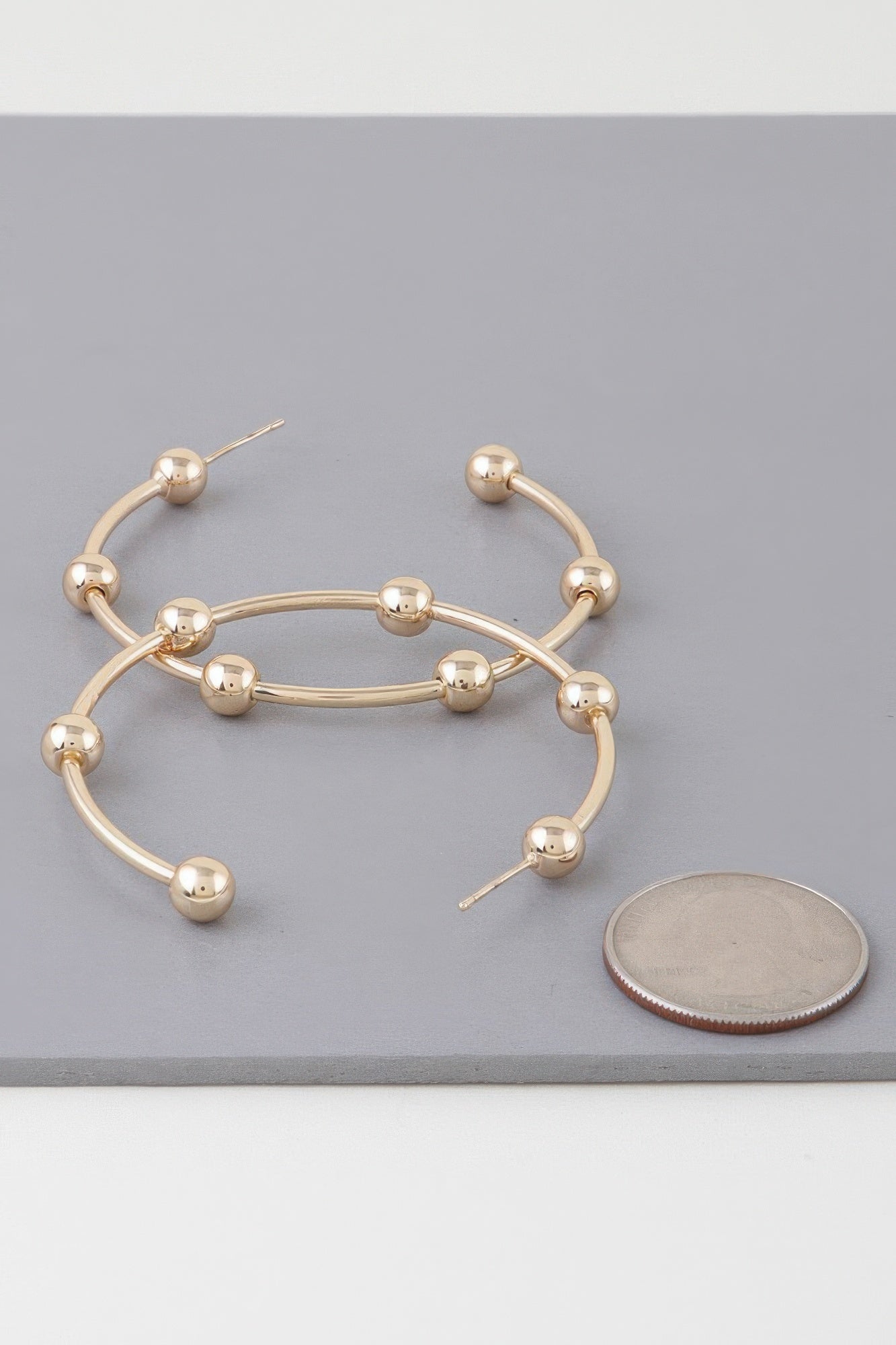 Goldfarbene Hoop-Ohrringe mit mehreren glänzenden Kugelperlen am Kreis