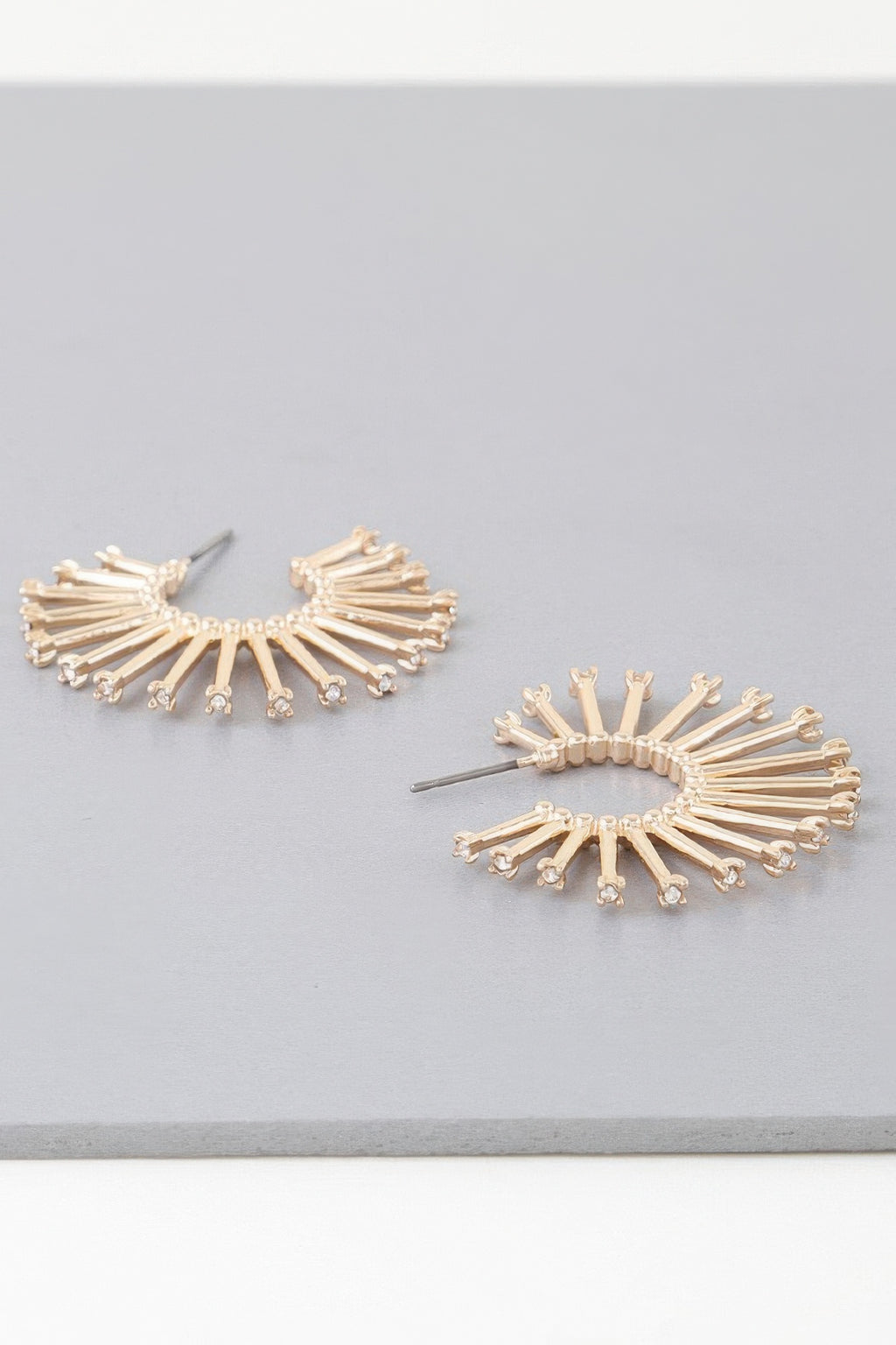 Sun hoop earrings in gold and silver tones, radiating bar design with clear stones