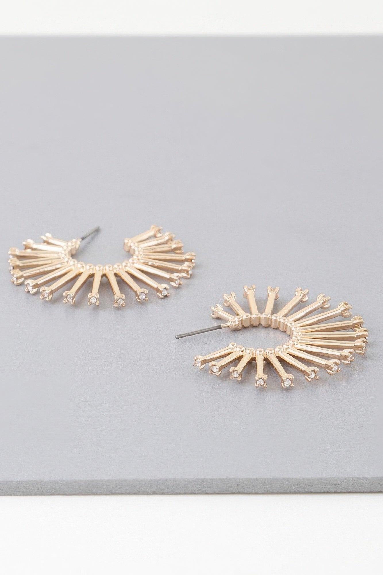 Sun hoop earrings in gold and silver tones, radiating bar design with clear stones