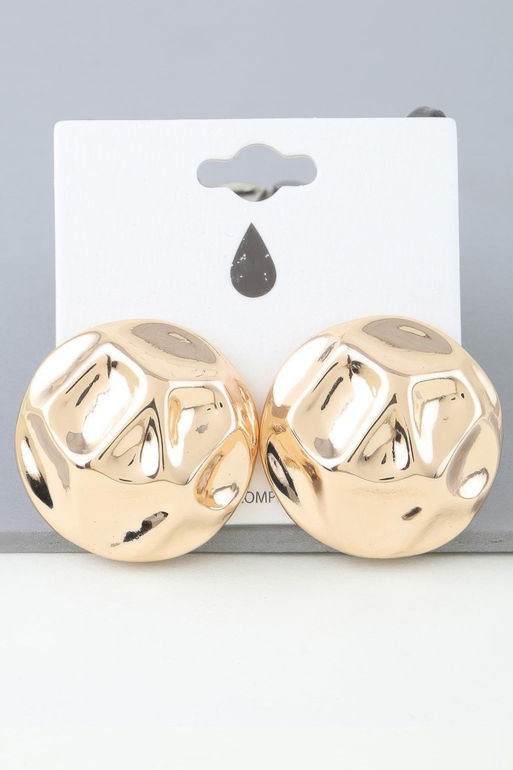 Gold tone hammered dome earrings, stud pair on card backing