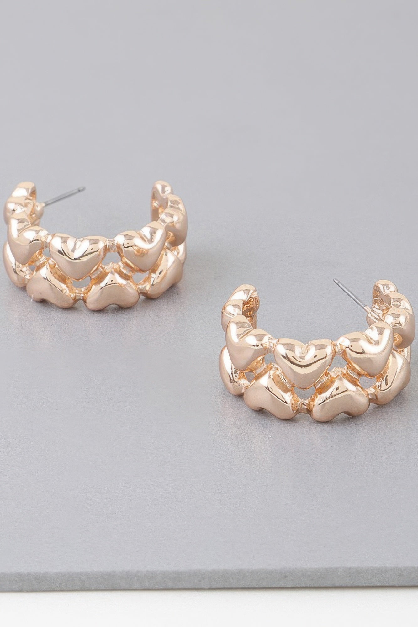 Gold-tone twin-heart hoop earrings with ridged scalloped heart links