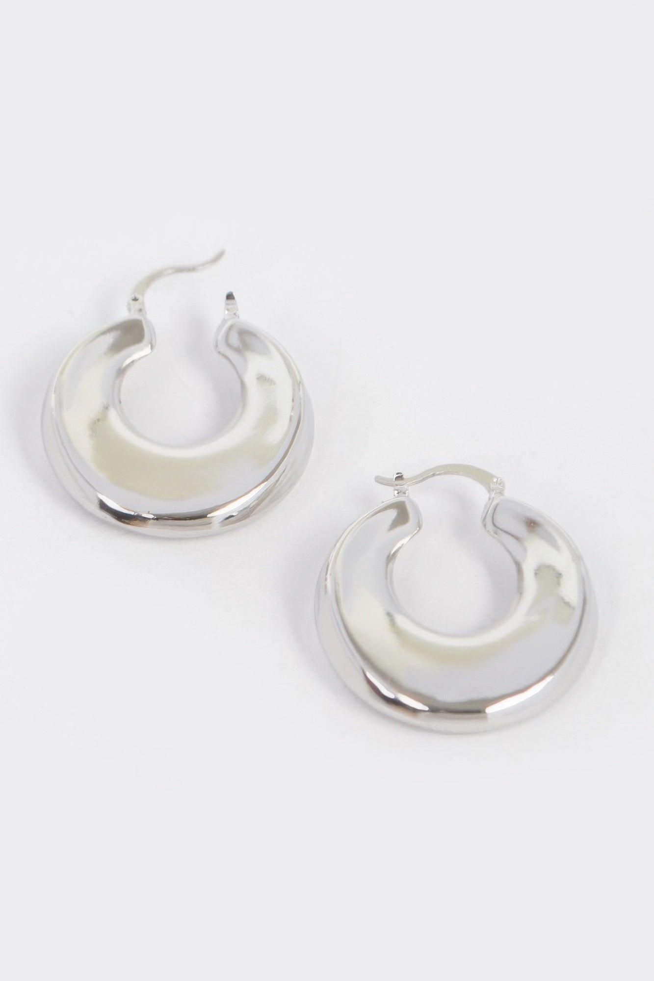 Vintage silver dip hoop metal earrings, curved crescent shape, shiny finish