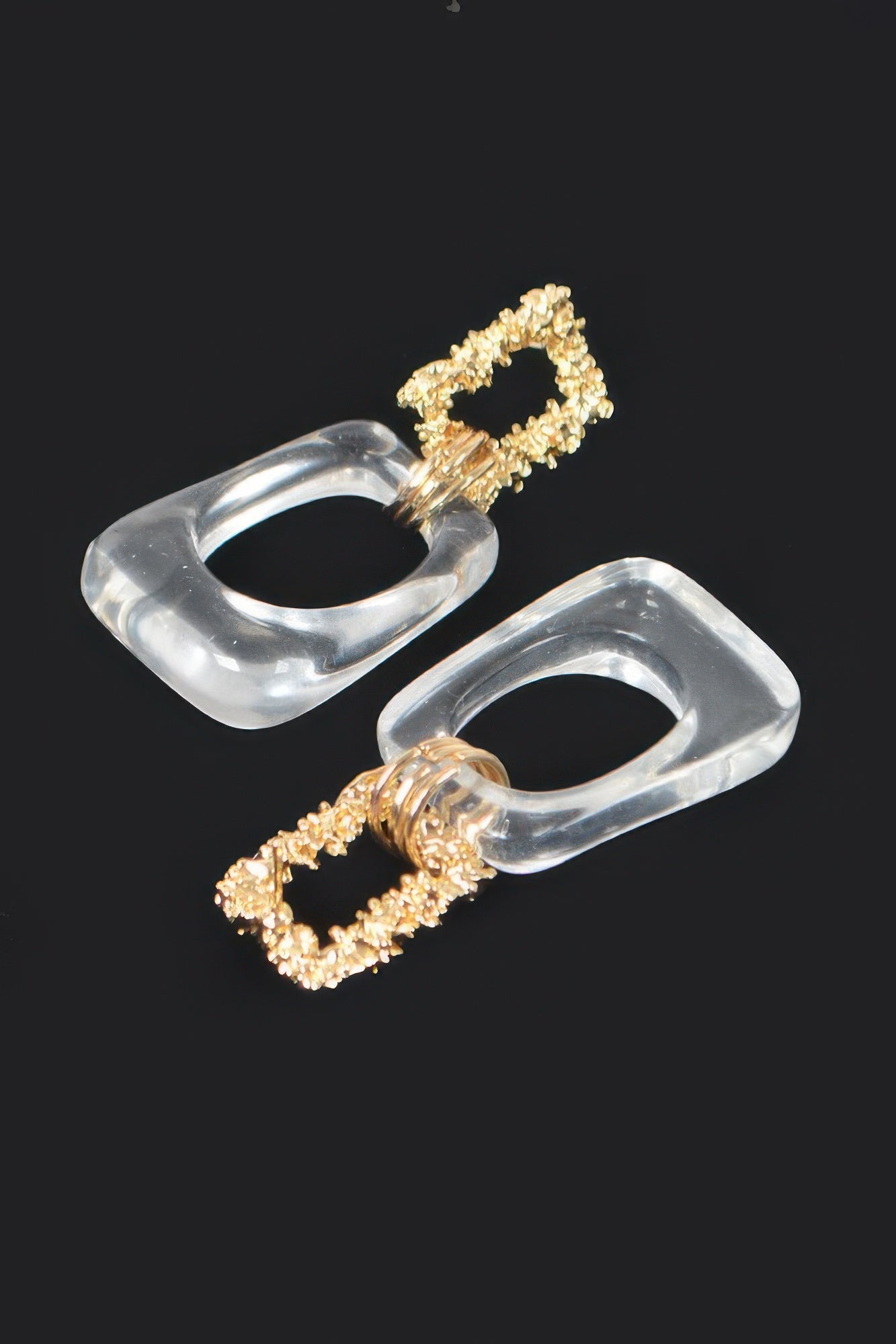 Clear lucite drop earrings with gold textured frames and intertwined spiral connector