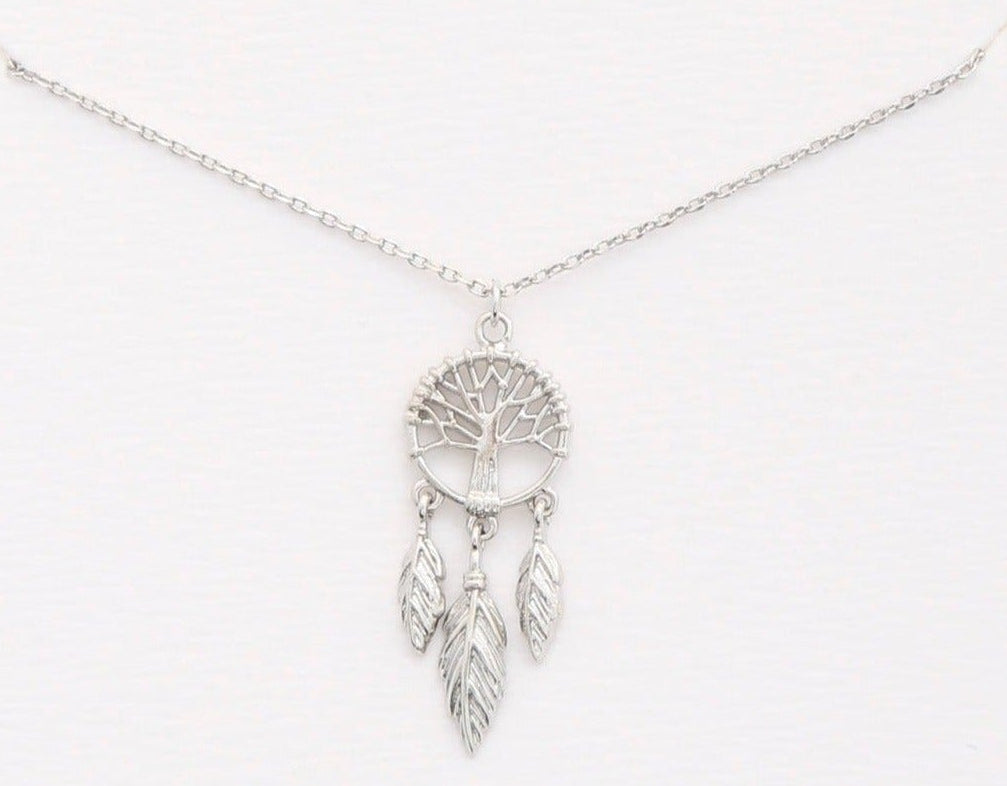 A silver dreamcatcher necklace with a detailed tree of life pendant and three hanging feathers, displayed on a clean white background.