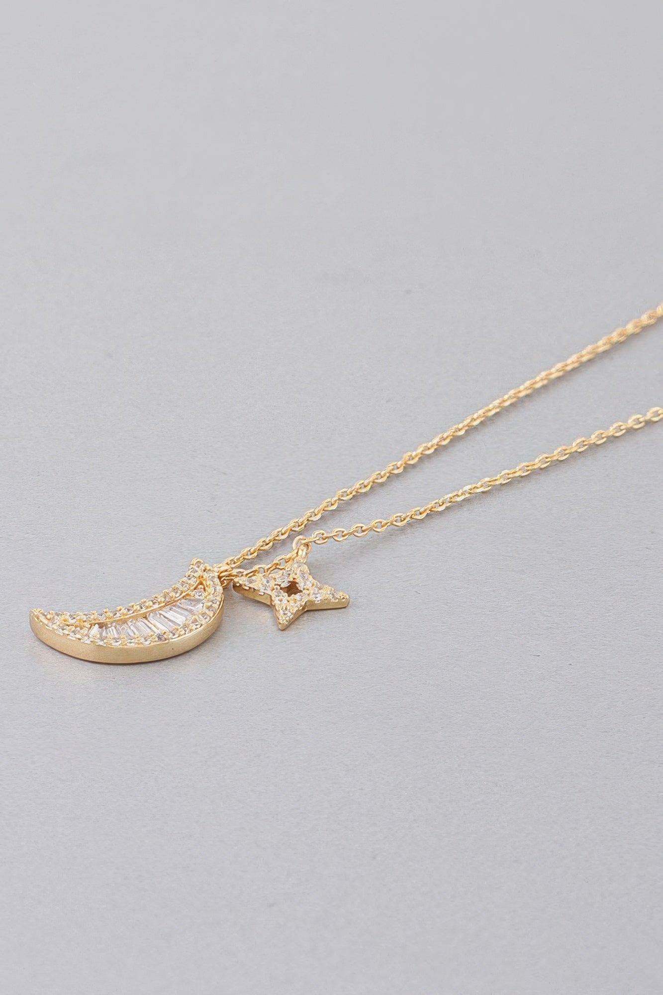 Gold tone Jeweled Sun N Moon necklace close-up: crescent moon and star charms