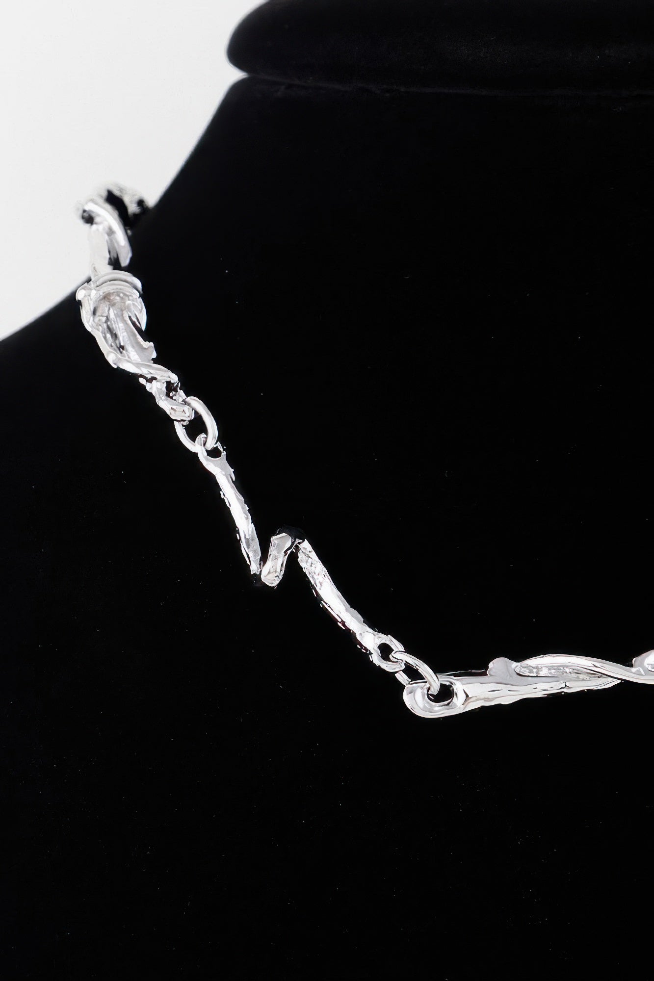 Silver multi-twisted abstract necklace close-up of chain links and clasp
