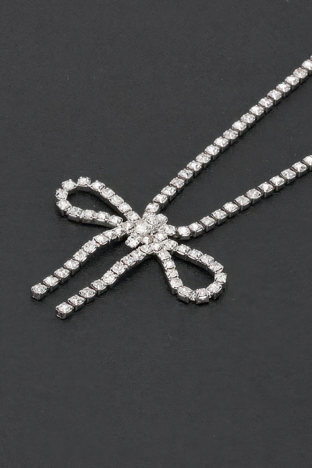 Rhinestone bow necklace close-up: clear bow pendant with sparkling stone rows