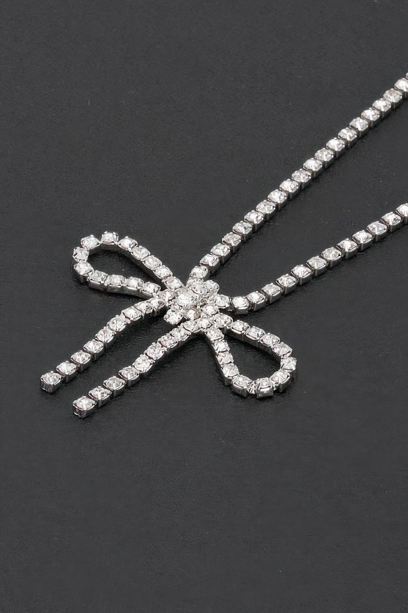 Rhinestone bow necklace close-up: clear bow pendant with sparkling stone rows