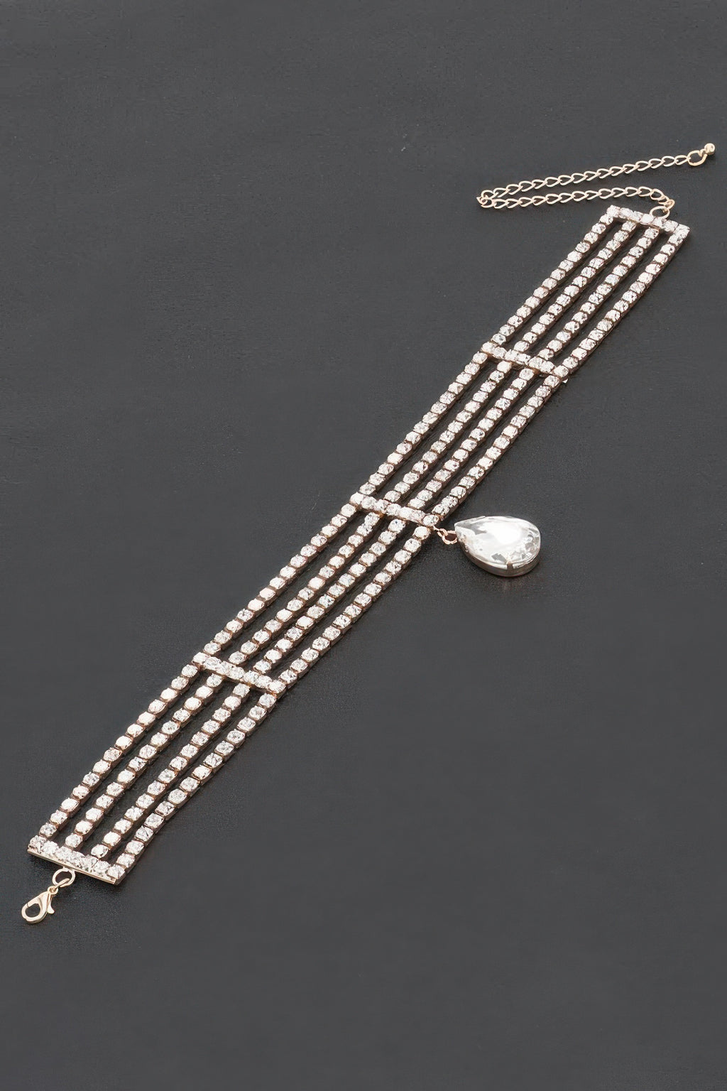 Rhinestone choker necklace laid flat; multi-row clear stones with teardrop centerpiece