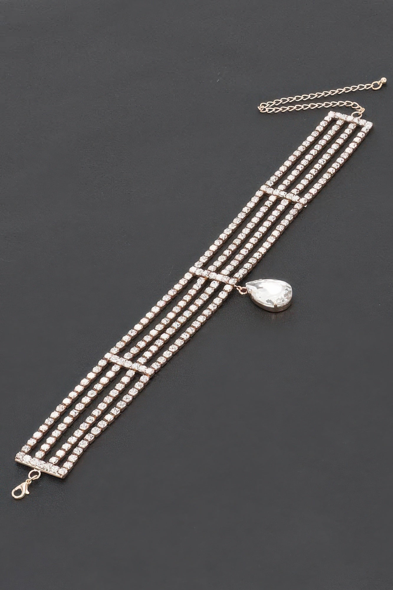 Rhinestone choker necklace laid flat; multi-row clear stones with teardrop centerpiece
