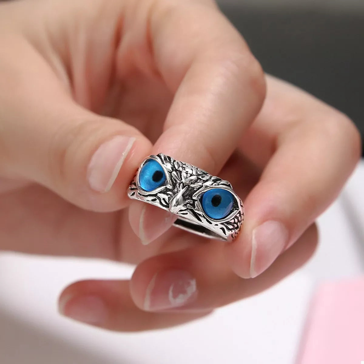 Silver owl eyes ring worn on finger, blue eye cabochons with textured metal band