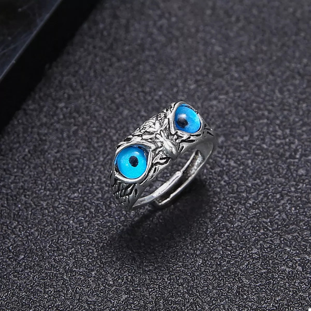 Silver owl eyes ring showing one blue eye cabochon and detailed silver texture
