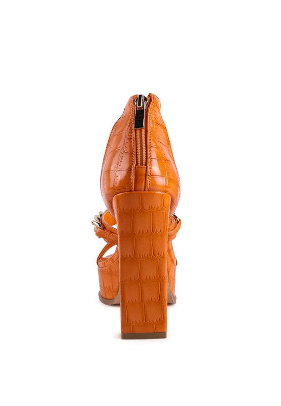 Orange zip-up platform sandals with high heel and chain detail on the back strap