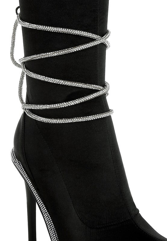 Black calf boots close-up: rhinestone strap bands and sparkling trim at the toe
