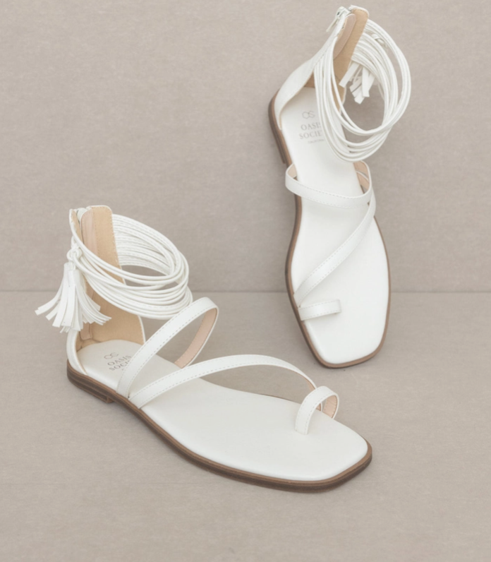 White strappy ankle wrap sandals with fringe tassels and flat leather-look sole