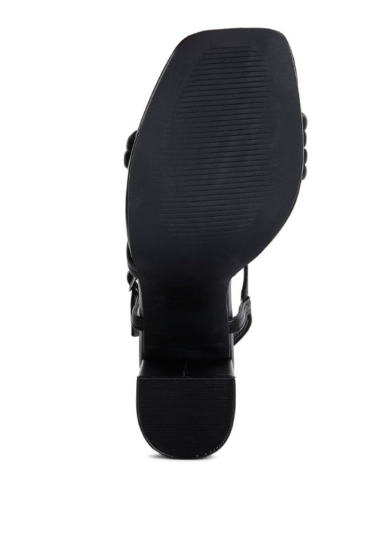 Black platform high-heel sandals outsole view showing tread