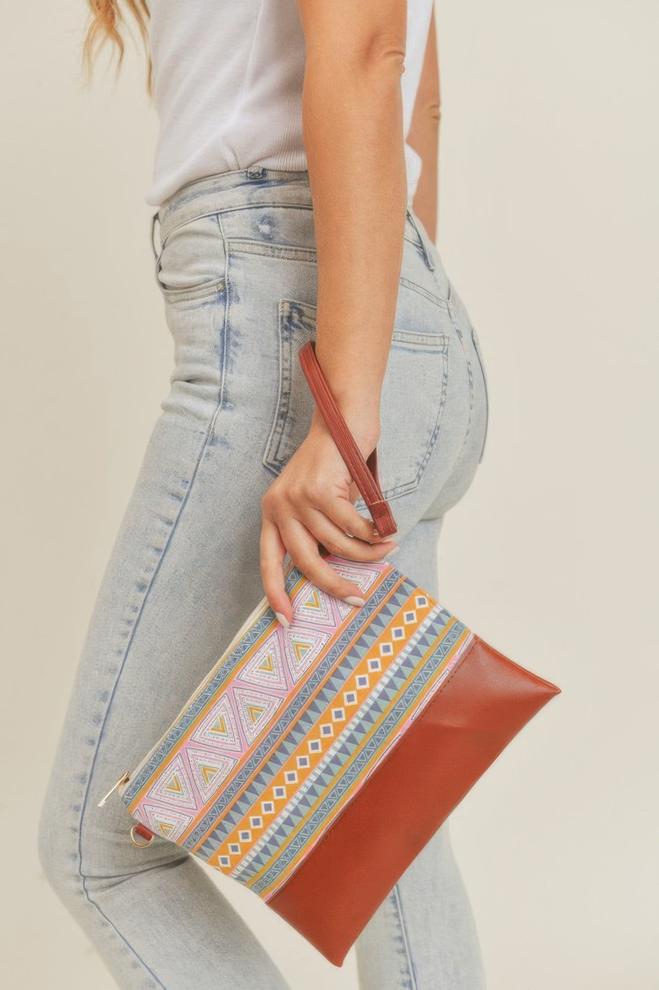Aztec crossbody bag worn across the body, multicolor Aztec stripe front with brown bottom