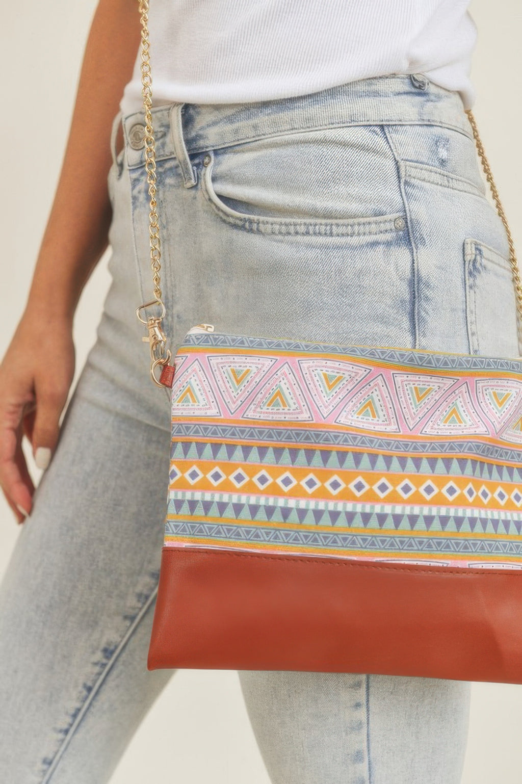 Close-up of Aztec crossbody bag: multicolor stripe band and brown front flap