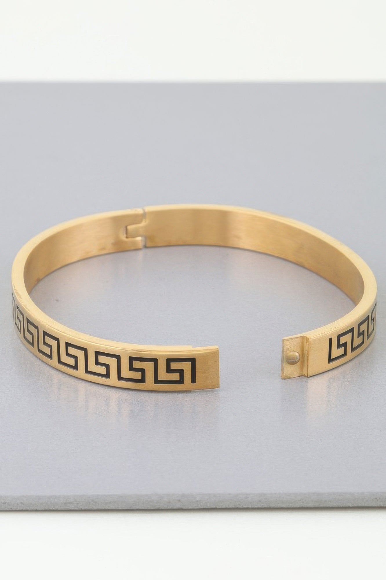 Gold Aztec Maze cuff with hinged clasp and dark Greek-key motif insets