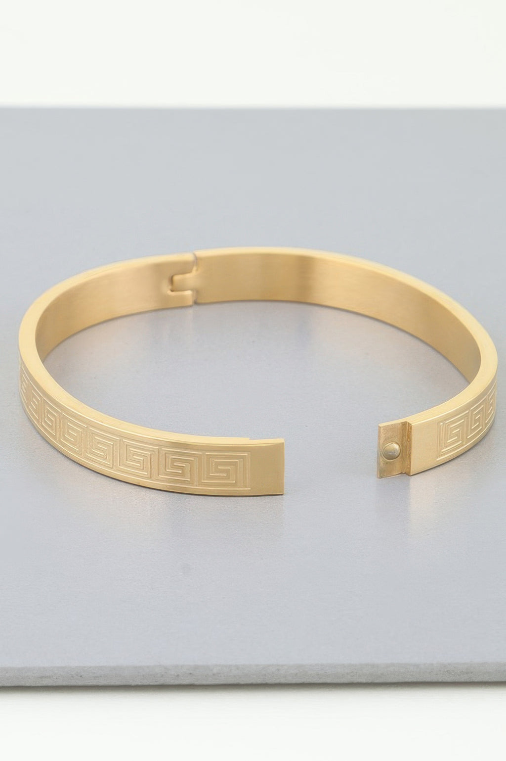 Goldfarbenes Azteken-Maze Armband mit eingravierter Verzierung und Druckverschluss-Detail