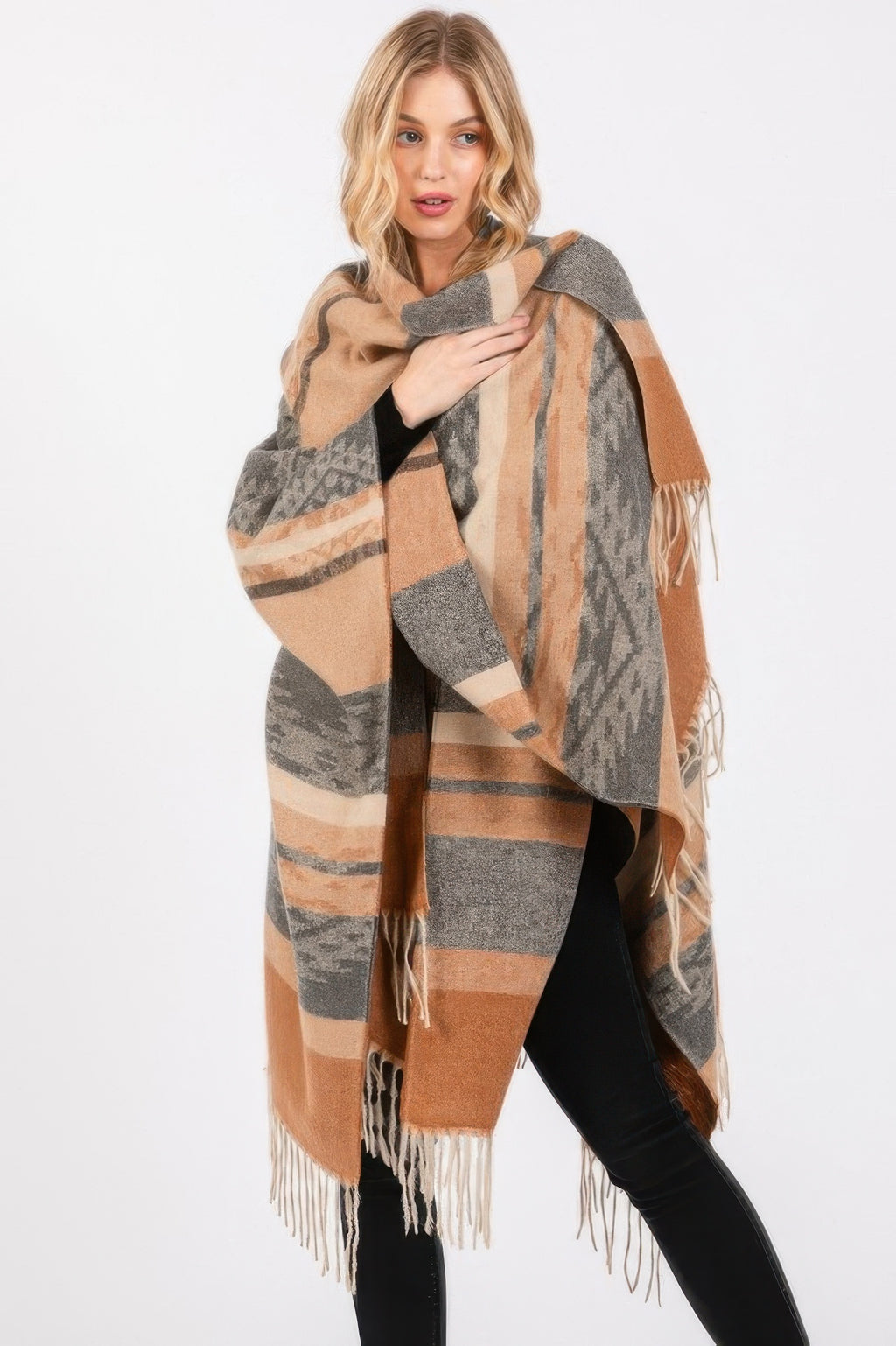 Taupe Aztec-pattern ruana draped over shoulders, tassel fringe along edges