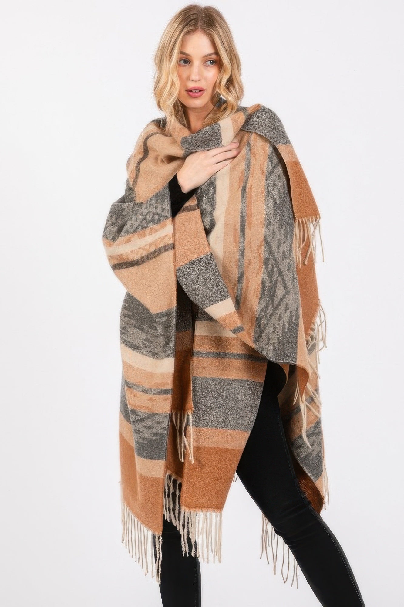 Taupe Aztec-pattern ruana draped over shoulders, tassel fringe along edges