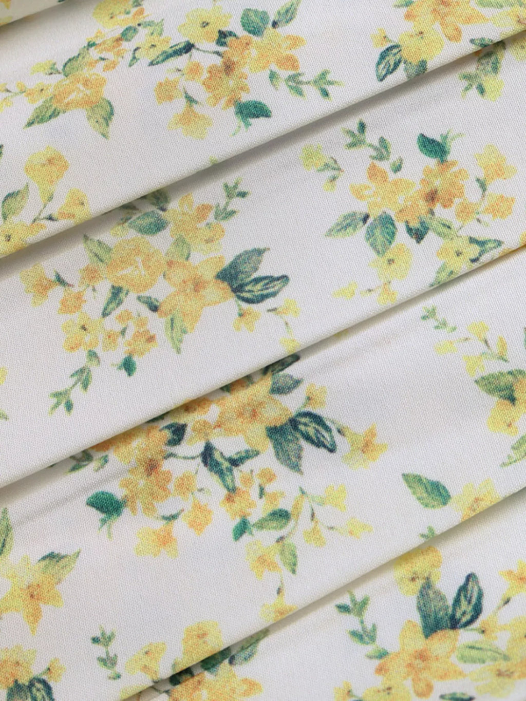 Yellow floral fabric with small green leaves, lightweight dress material