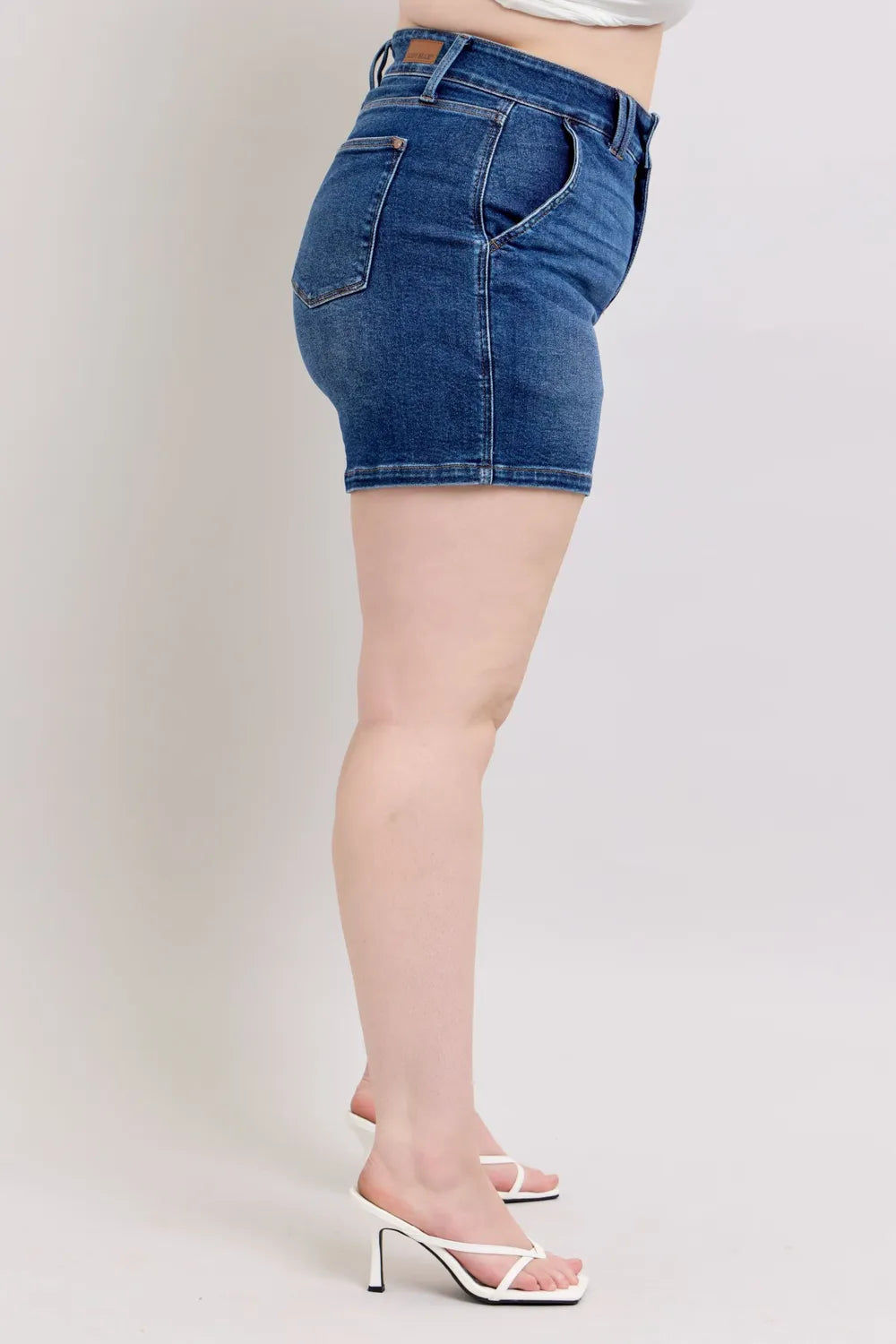 Side view of dark denim shorts with front pocket and belt loops