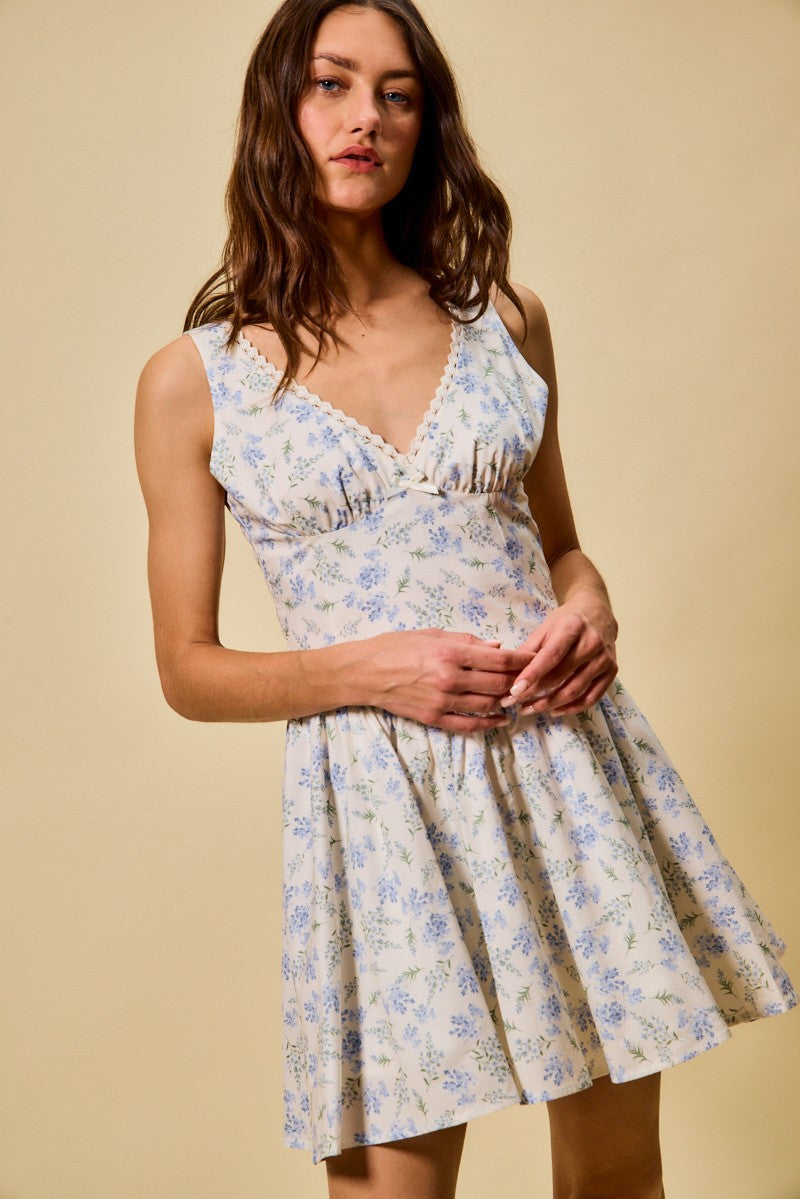 Blue floral dress with V-neck bodice, sleeveless cut, and gathered skirt