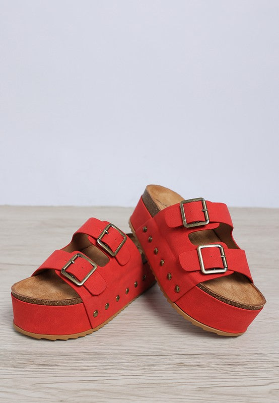 Red faux leather flatform sandals with stud trim and two adjustable buckle straps